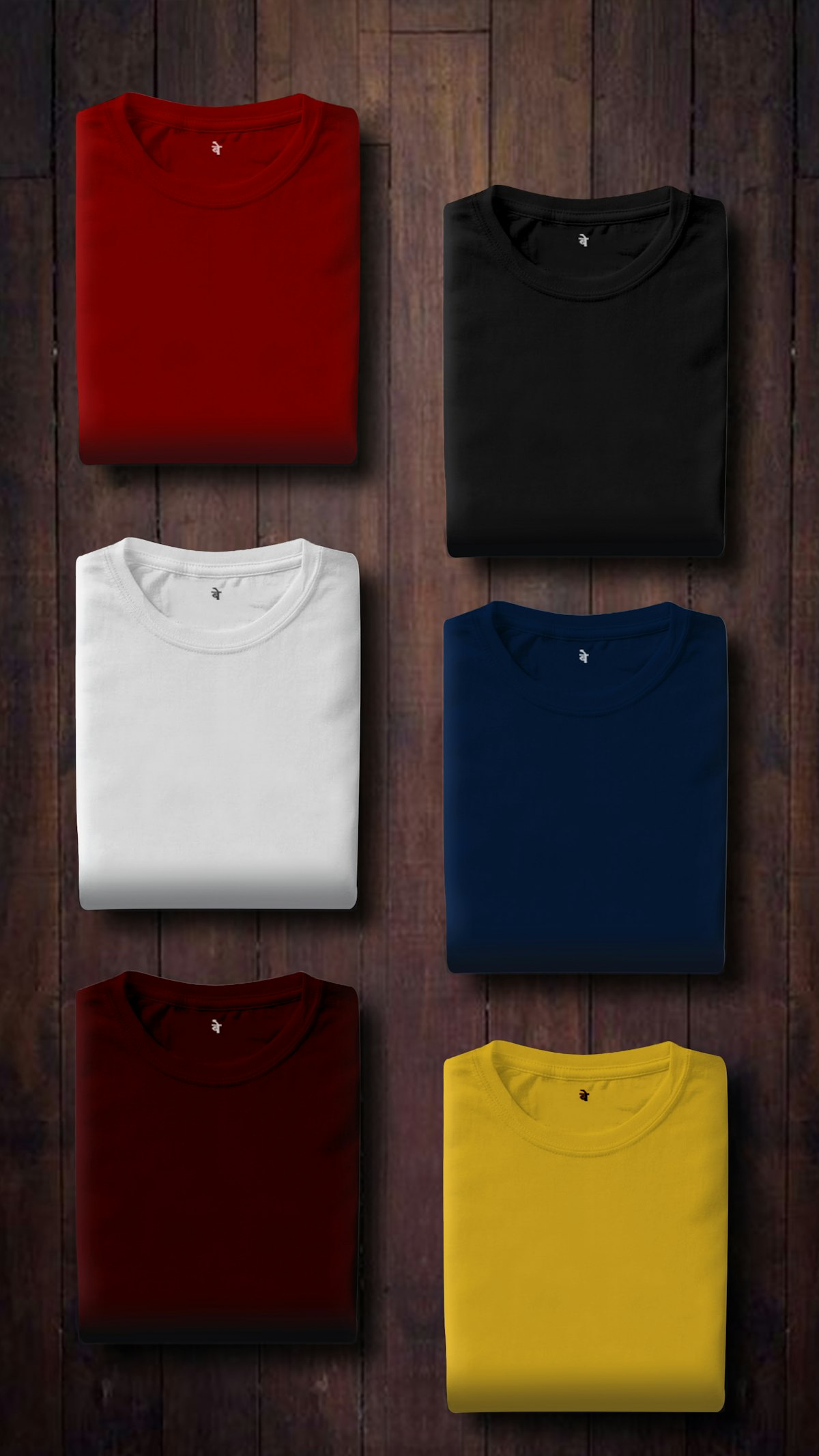 Folded white and navy T-shirts on a wooden surface